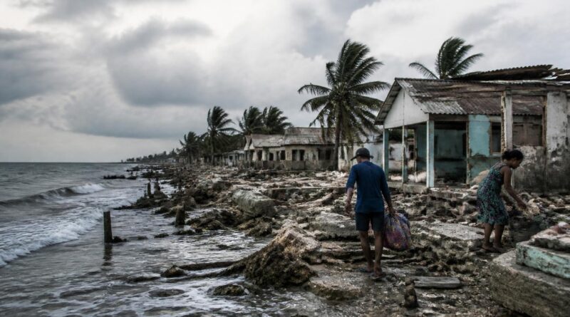 Warga di kawasan pesisir rentan menyiapkan barang di dekat rumah dan infrastruktur yang rusak akibat dampak perubahan iklim