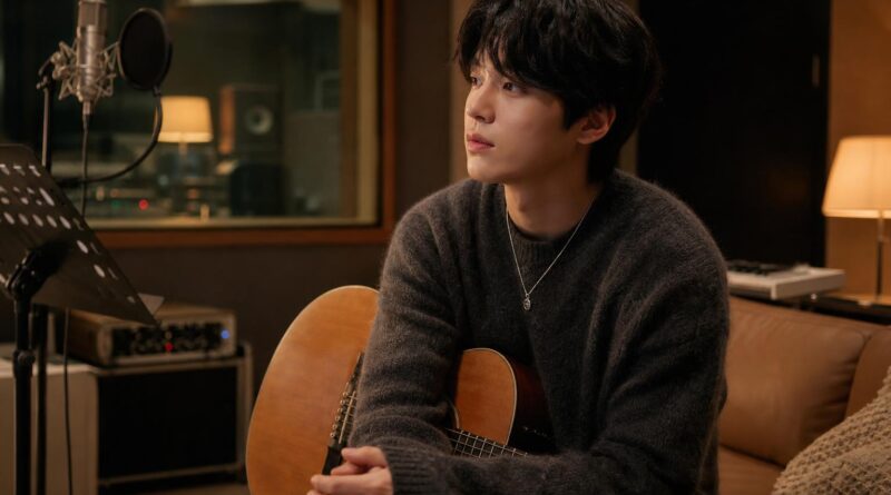 Penyanyi solo duduk di studio rekaman dengan gitar akustik dalam suasana hangat dan tenang