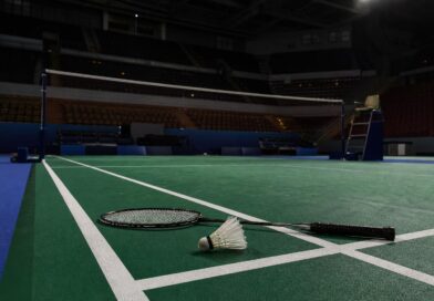 Lapangan bulu tangkis kosong di arena Asian Games dengan raket dan kok di dekat garis lapangan