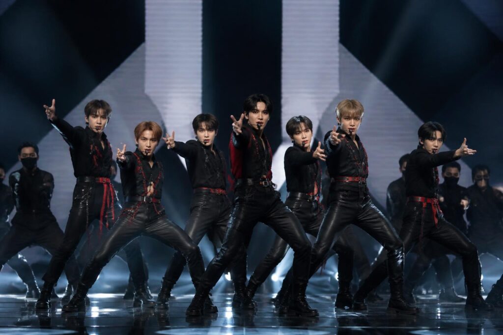 Penampilan kelompok idola K-pop dengan penari latar dalam koreografi berskala besar dan pencahayaan intens