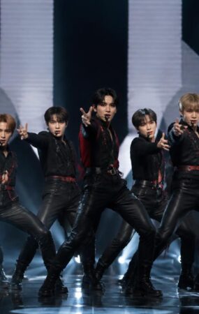 Penampilan kelompok idola K-pop dengan penari latar dalam koreografi berskala besar dan pencahayaan intens