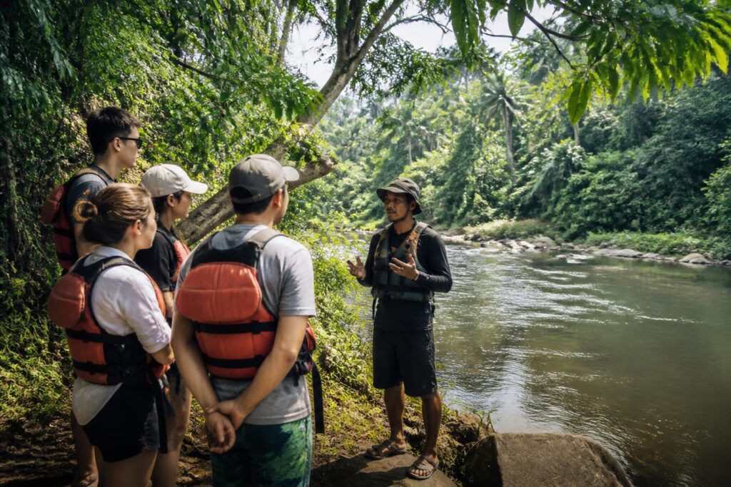 Pemandu lokal memberikan pengarahan keselamatan kepada wisatawan di tepi sungai kawasan alam