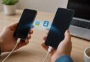 Dua ponsel Android berada di atas meja dengan kabel transfer dan simbol foto serta kontak di sekitarnya
