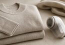 Sweater terlipat dan alat pencukur kain di atas meja untuk perawatan permukaan pakaian