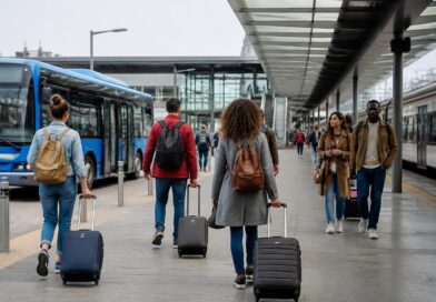 Wisatawan membawa ransel menunggu transportasi umum di area stasiun yang tertata