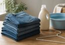 Celana jeans terlipat di dekat perlengkapan pencucian lembut untuk perawatan denim