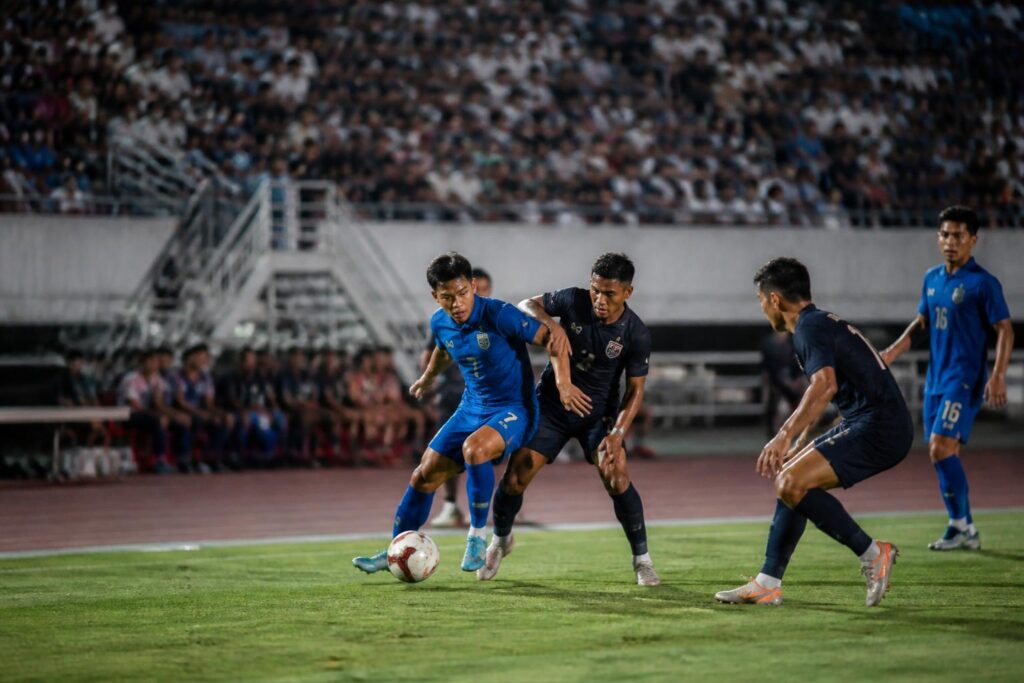 Suasana pertandingan sepak bola klub Asia Tenggara di stadion dengan pemain beradu di lapangan