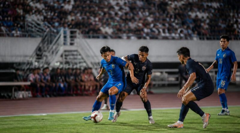 Suasana pertandingan sepak bola klub Asia Tenggara di stadion dengan pemain beradu di lapangan