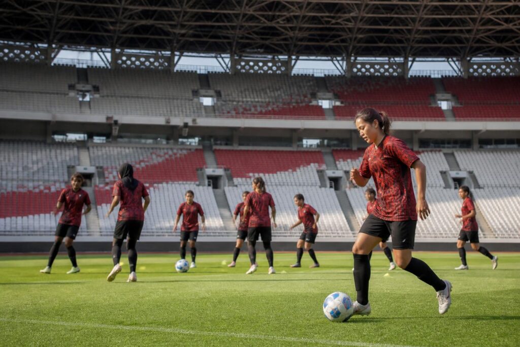 Pemain sepak bola putri melakukan pemanasan di lapangan stadion menjelang pertandingan liga di Jakarta