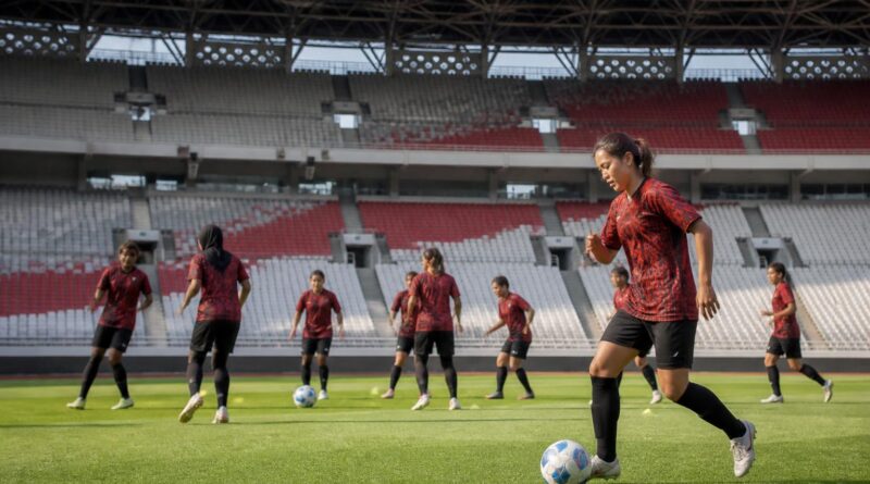 Pemain sepak bola putri melakukan pemanasan di lapangan stadion menjelang pertandingan liga di Jakarta