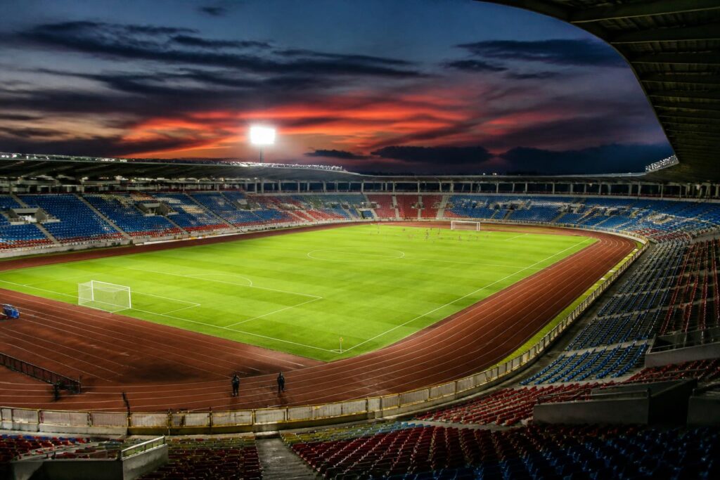 Lapangan stadion sepak bola Indonesia yang diterangi lampu pada suasana menjelang pertandingan