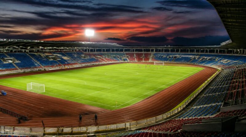 Lapangan stadion sepak bola Indonesia yang diterangi lampu pada suasana menjelang pertandingan
