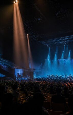 Suasana konser musik di arena Seoul dengan panggung bercahaya dan penonton dari belakang