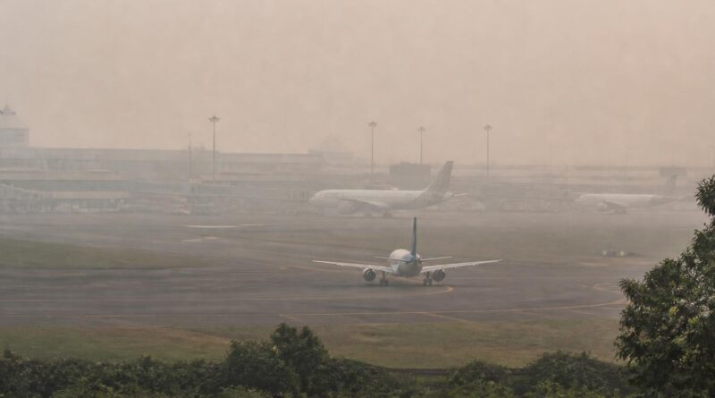 Landasan dan terminal bandara tampak samar dalam kondisi berkabut akibat gangguan jarak pandang