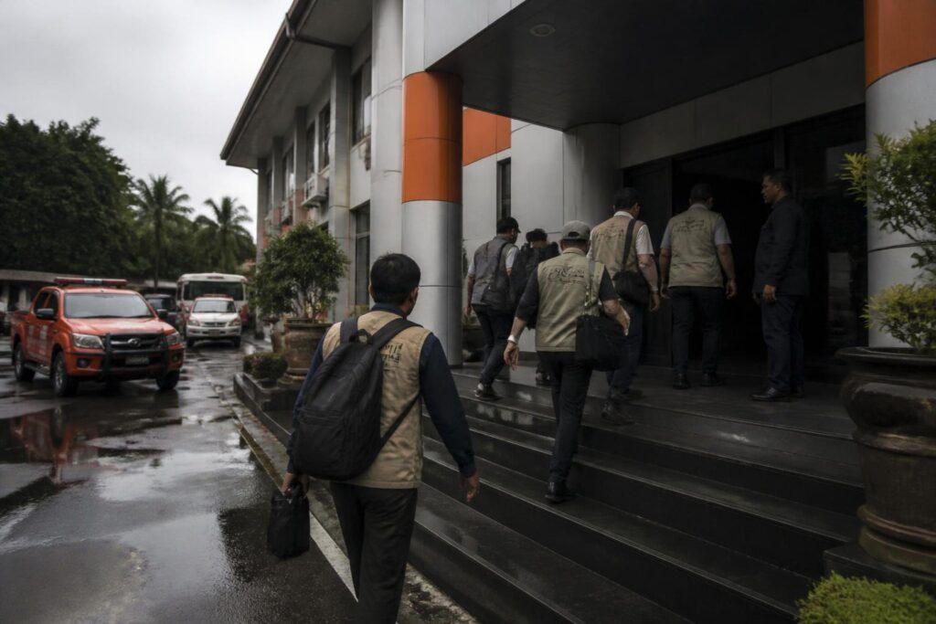 Petugas dan pejabat memasuki gedung kantor penanggulangan bencana dalam suasana pemeriksaan