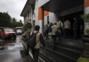 Petugas dan pejabat memasuki gedung kantor penanggulangan bencana dalam suasana pemeriksaan