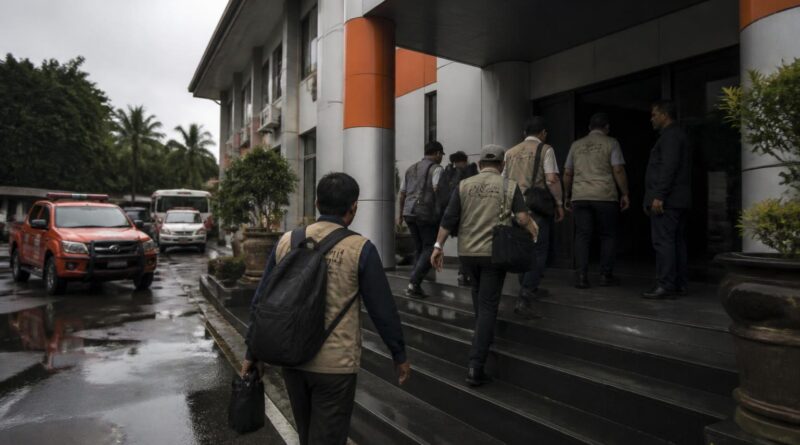 Petugas dan pejabat memasuki gedung kantor penanggulangan bencana dalam suasana pemeriksaan