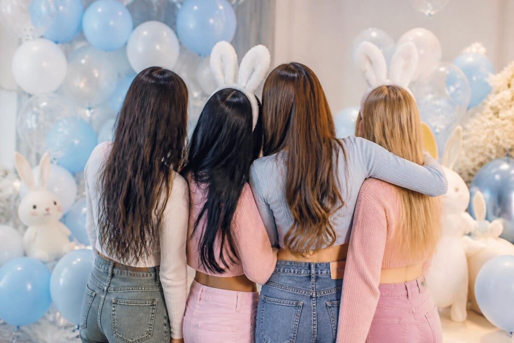 Ilustrasi suasana perayaan hari jadi keempat fandom Bunnies dengan empat figur anggota grup perempuan di studio bernuansa pastel.
