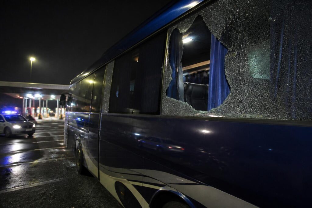 Bus rombongan tim sepak bola berada di area istirahat jalan tol dengan kaca samping yang pecah