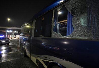 Bus rombongan tim sepak bola berada di area istirahat jalan tol dengan kaca samping yang pecah