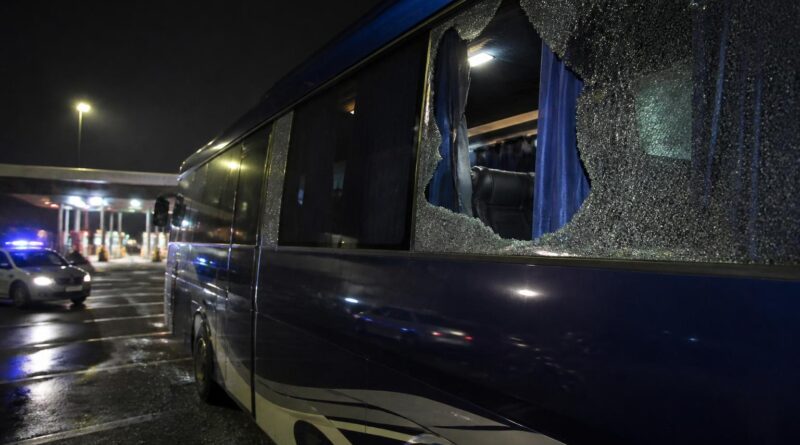 Bus rombongan tim sepak bola berada di area istirahat jalan tol dengan kaca samping yang pecah