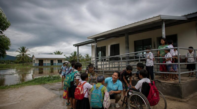 Guru dan siswa berkumpul di lingkungan sekolah yang aman dan inklusif untuk bersiap menghadapi risiko bencana iklim